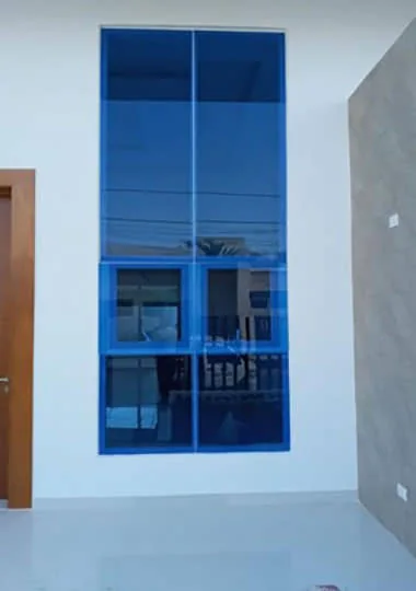 Fachada con ventanales de vidrio azul y perfiles de aluminio