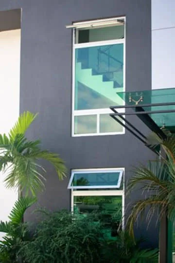 Fachada con ventanas proyectadas y vidrio verde